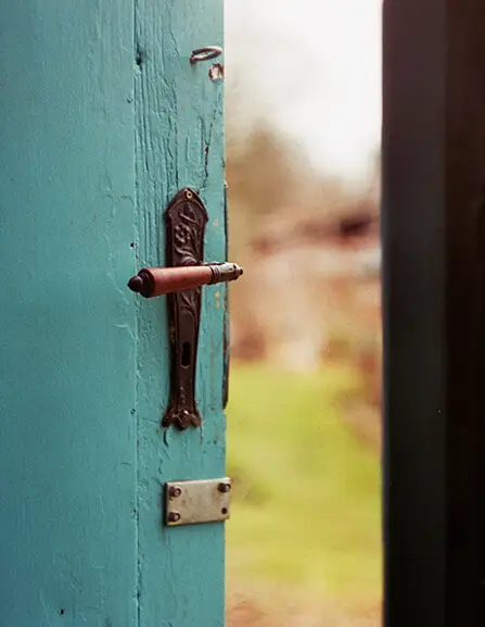 A door open slightly to show a garden but blurred out